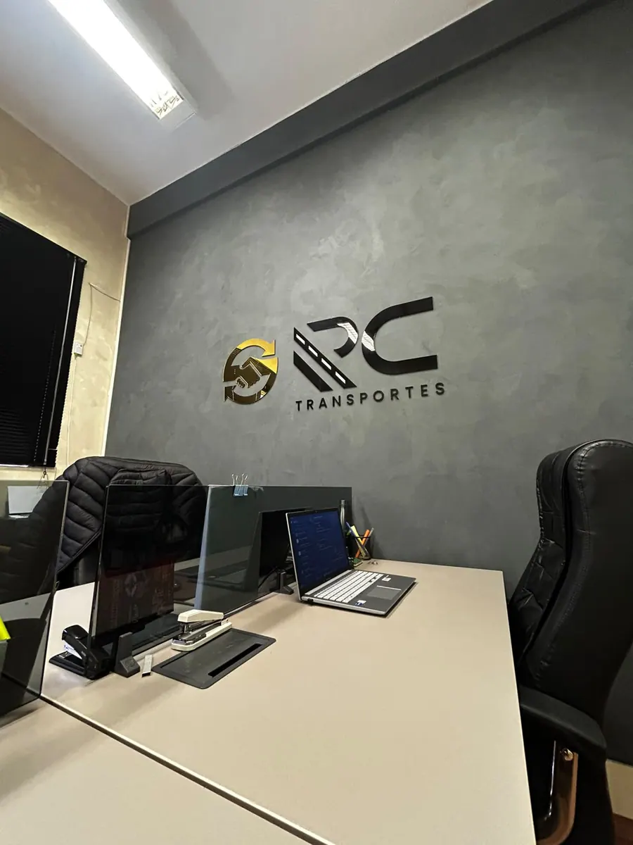 Escritório da RC Transportes com o logotipo da empresa na parede